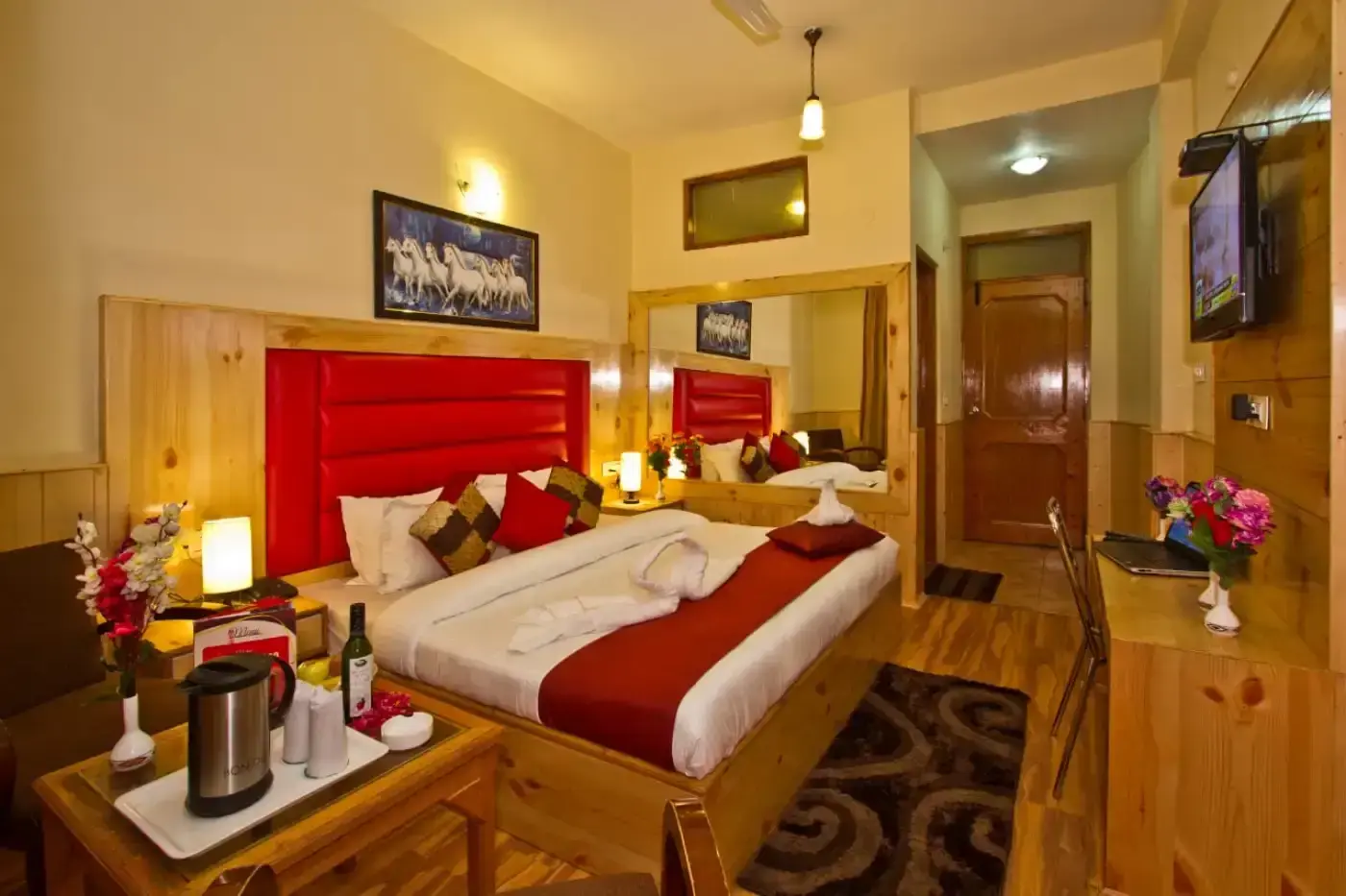 Romantic hotel room with rose petals on bed, wine