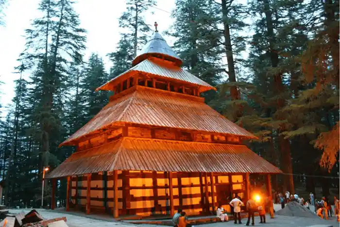 Wooden pagoda-style temple in a forest setting, Himachal Pradesh.